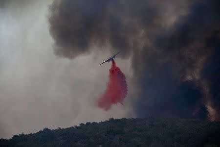 Firefighters battle a blaze in San Marcos, California May 14, 2014. REUTERS/Sam Hodgson