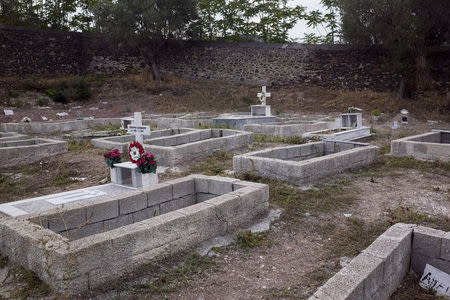 Graves of Afghan refugees, who drowned in 2007 at sea during their attempts to cross a part of the Aegean Sea from the Turkish coast, are seen at the Saint Panteleimon cemetery of Mytilene, on the Greek island of Lesbos, October 7, 2015. The tombstone reads "Unknown, Muhammad". Buried beneath low mounds of earth, facing Mecca, lay Afghan, Iraqi and Syrian refugees who drowned this summer in the Aegean Sea trying to reach Europe in flimsy inflatable boats. Now there is no room left in the narrow plot of land in the pauper's section of St. Panteleimon cemetery, close to where the colonnaded tombs of wealthy Greeks are built in the classical Greek style, and flowers adorn lavish marble graves. No one can say where the next bodies will be buried. Nearly half a million people, mostly Syrians, Afghans and Iraqis fleeing war and persecution, have made the dangerous journey to Europe this year. Almost 3,000 have died, the U.N. refugee agency estimates. To match story EUROPE-MIGRANTS/GREECE-DEAD Picture taken October 7, 2015. REUTERS/Dimitris Michalakis