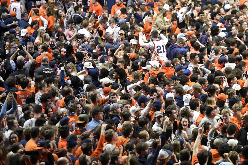 FILE - Illinois fans fill the court at the conclusion of an NCAA college basketball game against Iowa, Sunday, March 6, 2022, in Champaign, Ill. Recent incidents in college basketball have underscored the potential dangers that come from jubilant fans storming the court after the game comes to an end. Finding a solution is proving to be a challenge. (AP Photo/Michael Allio, File)