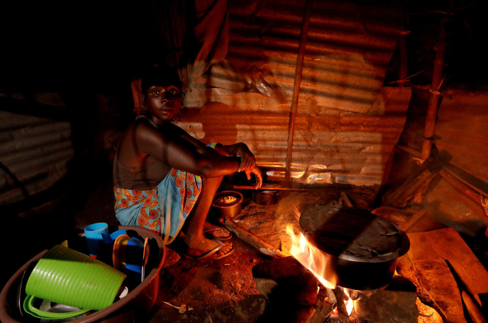 Maria Jofresse cooks in her makeshift shelter in the aftermath of Cyclone Idai, April 4, 2019. Jofresse lost her two children to the storm. "People suffered indeed, but no one suffered as I did because I lost the most precious things I had — my kids," she said. (Photo: Zohra Bensemra/Reuters)