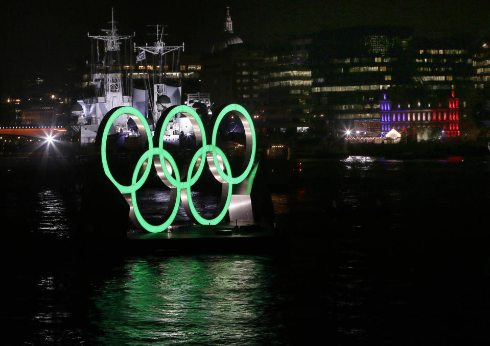 FILE - Olympic rings are illuminated in front of HMS Belfast on the River Thames, during the Opening Ceremony of the 2012 Summer Olympics, Friday, July 27, 2012, in London. The International Olympic Committee has signed Anheuser-Busch InBev as the first beer brand in the 40-year history of its sponsorship program, which earns billions of dollars for the organization and international sports. (AP Photo/Kirsty Wigglesworth, File)