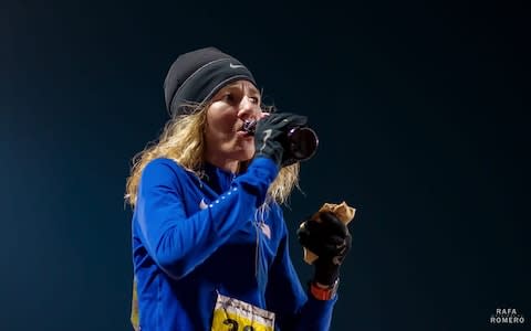 Camille Herron sips a beer and holds a burrito during a race - Credit: Rafa Romero