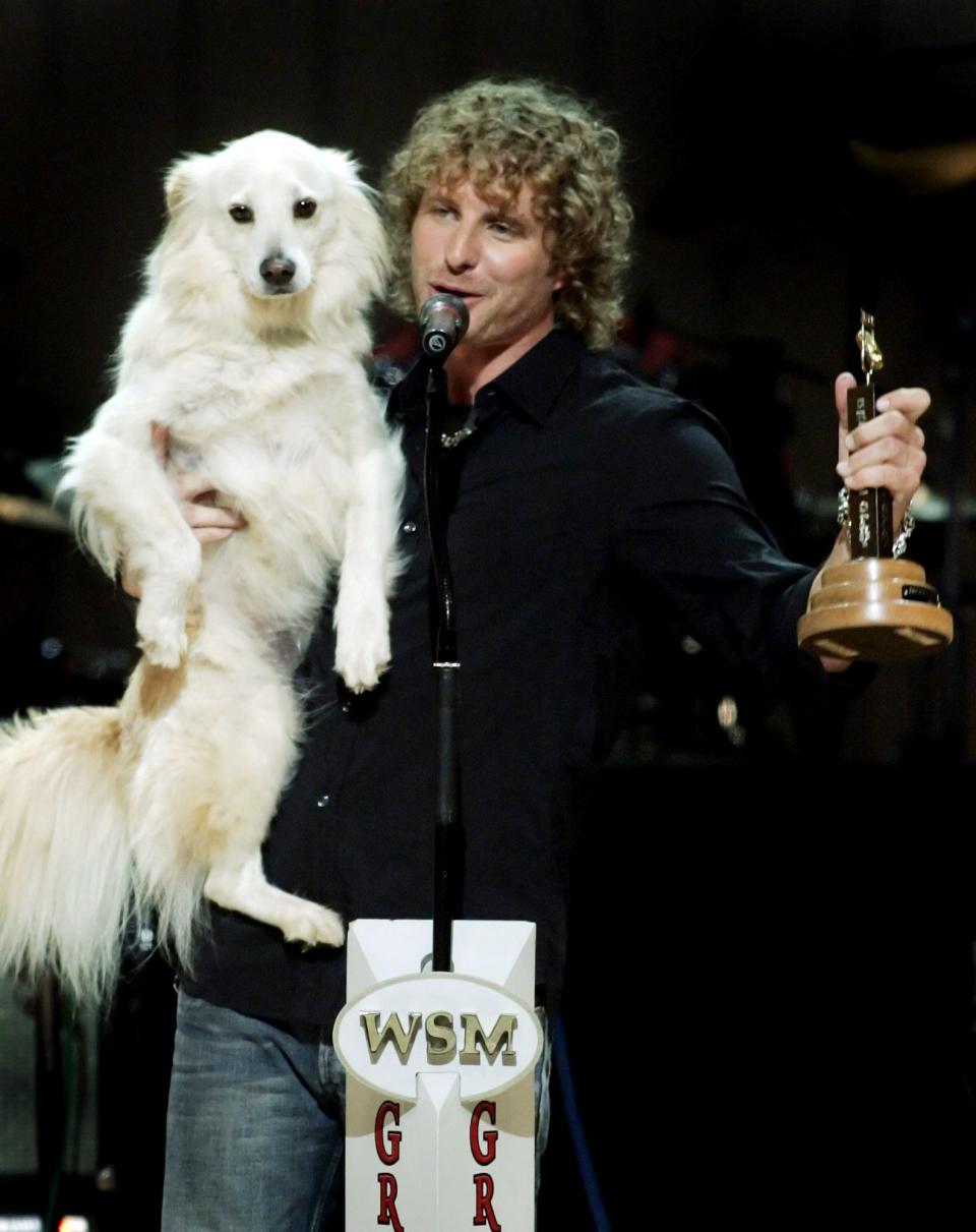 Country singer Dierks Bentley holds his dog, Jake, after accepting the Grand Ole Opry Member award during his induction at the Grand Ole Opry House on Oct. 1, 2005.