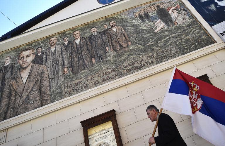 Un hombre con la bandera serbia camina junto a un mural representando a Princip, en la localidad serbo-bosnia de Visegrado.