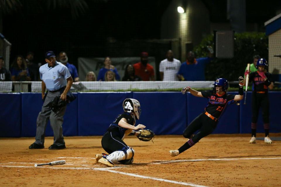 Palm Beach Gardens softball Nola Ferriter (13) slides into home against Wellington on Friday, March 1, 2024.