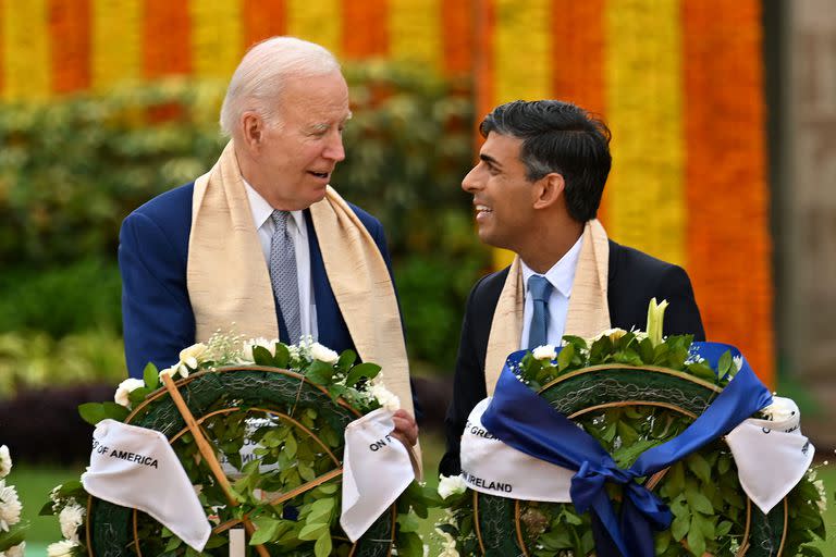 El presidente estadounidense Joe Biden (izq.) habla con el primer ministro británico Rishi Sunak antes de presentar sus respetos en el monumento a Mahatma Gandhi en Raj Ghat, al margen de la cumbre del G20 en Nueva Delhi, el 10 de septiembre de 2023. (Foto de Kenny HOLSTON / POOL / AFP)