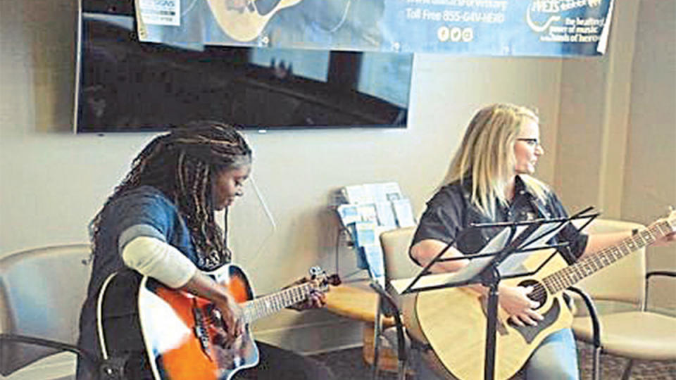 Angela and Taylor playing the guitar