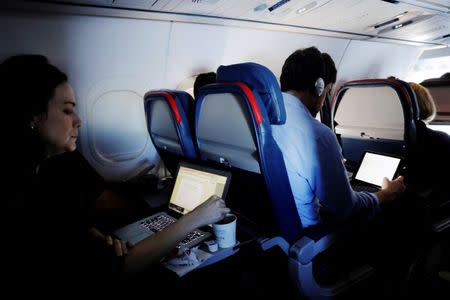 FILE PHOTO -- Passengers use their laptops on a flight out of John F. Kennedy (JFK) International Airport in New York, U.S., May 26, 2017. Picture taken May 26, 2017. REUTERS/Lucas Jackson/File Photo