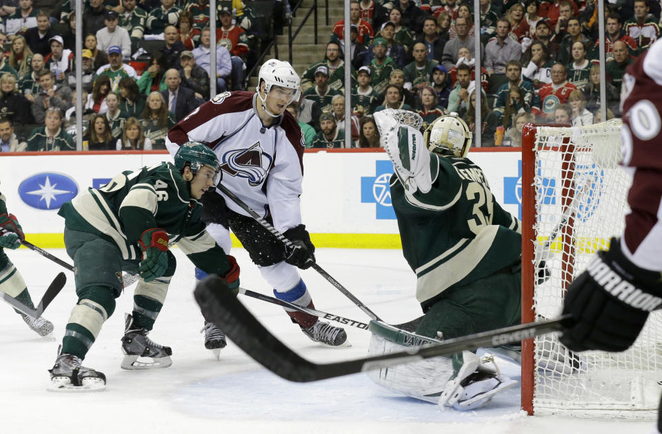 Colorado Avalanche defenseman Nick Holden, center, scores on Minnesota Wild goalie Darcy Kuemper, right, in front of Wild defenseman Jared Spurgeon (46) during the second period of Game 6 of an NHL hockey first-round playoff series in St. Paul, Minn., Monday, April 28, 2014. (AP Photo/Ann Heisenfelt)