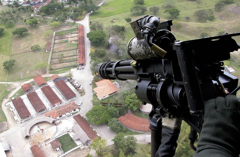 Foto de archivo. Un policía colombiano sostiene un arma en un helicóptero que sobrevuela una propiedad del acusado narcotraficante Luis Hernando Gómez, conocido como "Rasguño", en Cartago, departamento del Valle del Cauca