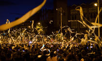 Demonstrators throw paper toilet rolls into the air during a protests in Barcelona, Spain, Wednesday, Oct. 16, 2019. Protesters in Barcelona are throwing hundreds of white paper toilet rolls into the air to show their anger over lengthy prison sentences given to separatist Catalan leaders. The demonstration Wednesday evening in the Catalan capital is the third straight day of protests since the Supreme Court handed down the sentences. (AP Photo/Emilio Morenatti)