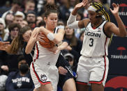 UConn's Lou Lopez-Senechal, center, wrestles the ball from Georgetown's Graceann Bennett, left, as UConn's Aaliyah Edwards, right, defends in the second half of an NCAA college basketball game, Sunday, Jan. 15, 2023, in Hartford, Conn. (AP Photo/Jessica Hill)