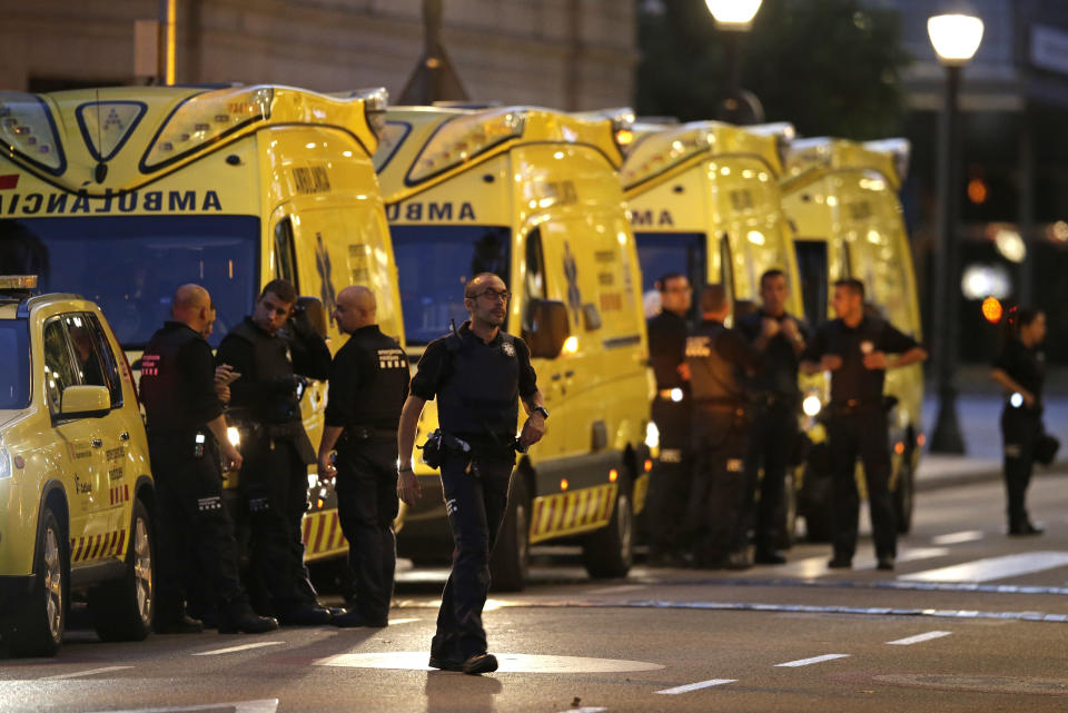 Emergency workers stand on a blocked street in Barcelona, Spain, Thursday, Aug. 17, 2017. A white van jumped up onto a sidewalk and sped down a pedestrian zone Thursday in Barcelona’s historic Las Ramblas district, swerving from side to side as it plowed into tourists and residents. Police said 13 people were killed and more than 50 wounded in what they called a terror attack. (AP Photo/Manu Fernandez)