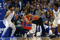 Florida's Kerry Blackshear Jr., middle, stumbles between Kentucky's Nick Richards (4) and Ashton Hagans (0) in the first half of an NCAA college basketball game in Lexington, Ky., Saturday, Feb. 22, 2020. (AP Photo/James Crisp)