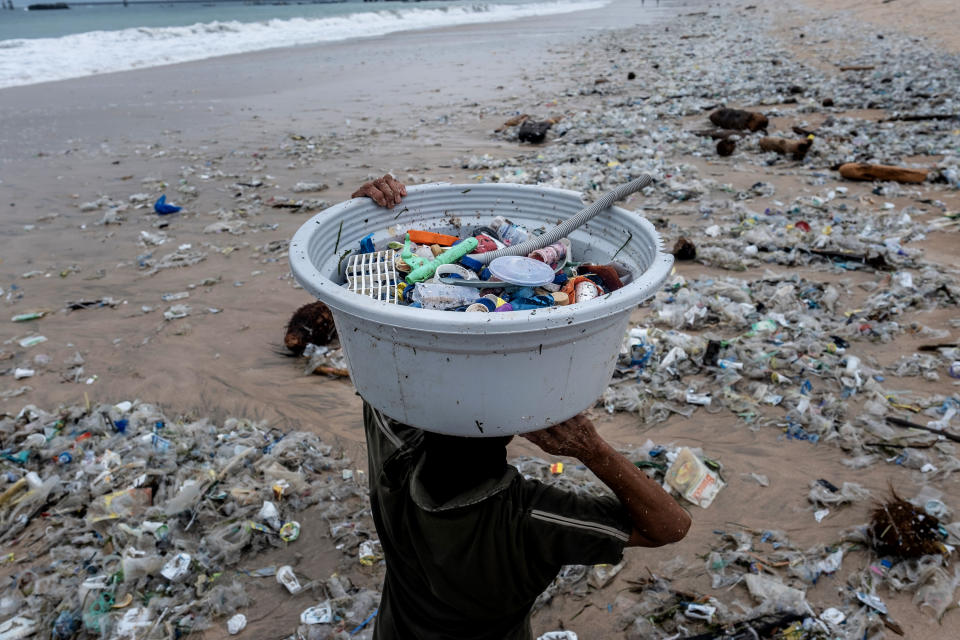 BALI, INDONESIA - JANUARY 30 : Saarinah (45) carries recyclable plastic trash on January 30, 2021 in Kedonganan, Bali, Indonesia. During the northwest monsoon season, she works to collect the recyclable plastic trash which brought in by the strong waves. She can collect 8kg per day and earns Rp.4000 per kg. In Bali, famed among tourists for its beaches and sunsets, the northwest monsoon brings a different kind of arrival - vast amounts of plastic waste. From December to March, so much trash washes up on the beaches that the local government struggles to keep up and clean up. Locals and workers have together been collecting 80 tonnes of waste a day as it washes ashore at world-famous beaches from Seminyak to Kuta, the local government said. Almost 75 percent of it is plastic, according to a study by the Center of Remote Sensing and Ocean Sciences at Bali's Udayana University. In the absence of tourism due to Covid-19, the trash problem has become obvious on beaches almost entirely devoid of visitors. Indonesia is part of the U.N.'s Clean Seas campaign, which aims to halt the tide of plastic trash polluting the oceans. As part of its commitment, the government has vowed to reduce marine plastic waste by 70 percent by 2025. (Photo by Agung Parameswara/Getty Images)