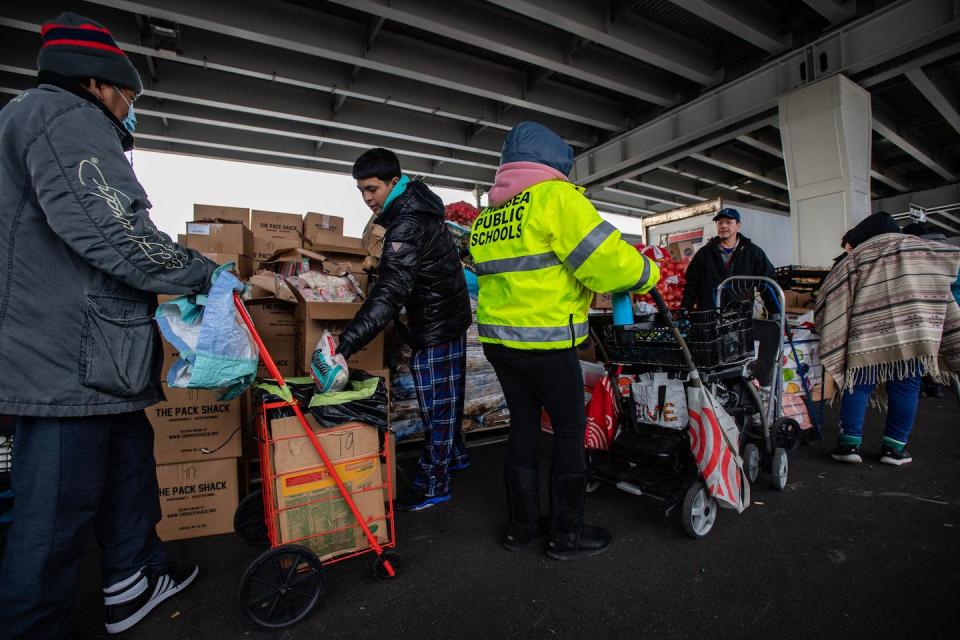 Food is distributed at a food and toy holiday pantry run by La Colaborativa and the Salvation Army in Chelsea, Mass. <a href="https://www.gettyimages.com/detail/news-photo/food-is-given-to-those-in-line-at-a-food-and-toy-holiday-news-photo/1245786431?adppopup=true" rel="nofollow noopener" target="_blank" data-ylk="slk:Joseph Prezioso/AFP via Getty Images;elm:context_link;itc:0;sec:content-canvas" class="link ">Joseph Prezioso/AFP via Getty Images</a>