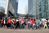 Protesters cross the road as they march in Yangon, Myanmar on Sunday, Feb. 7, 2021. Thousands of people rallied against the military takeover in Myanmar's biggest city on Sunday and demanded the release of Aung San Suu Kyi, whose elected government was toppled by the army that also imposed an internet blackout. (AP Photo)