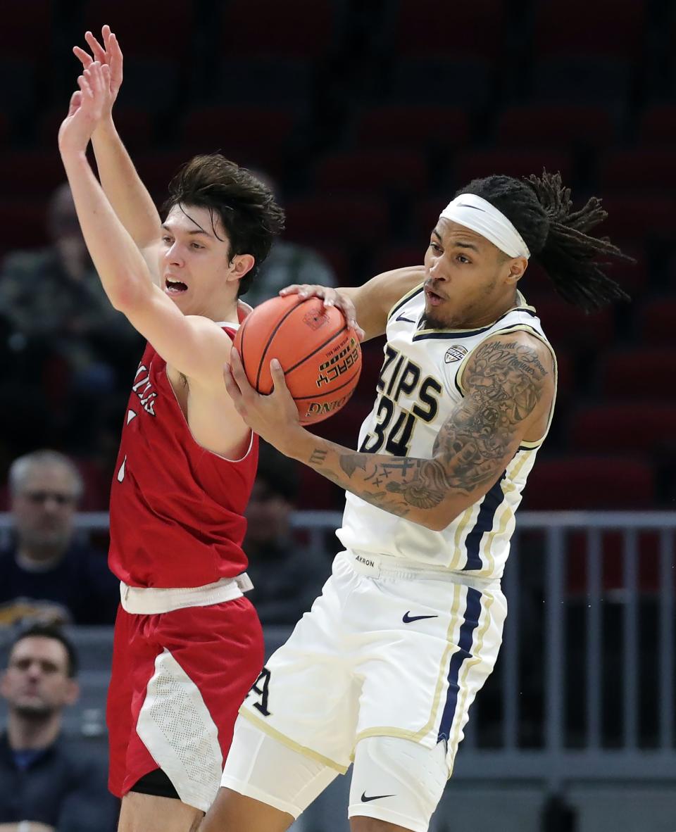 Akron Zips guard Nate Johnson (34) brings down a rebound against Miami (OH) Redhawks guard Bradley Dean (1) during the second half of an NCAA college basketball game in the quarterfinals of the Mid-American Conference Tournament at Rocket Mortgage FieldHouse, Thursday, March 14, 2024, in Cleveland, Ohio.