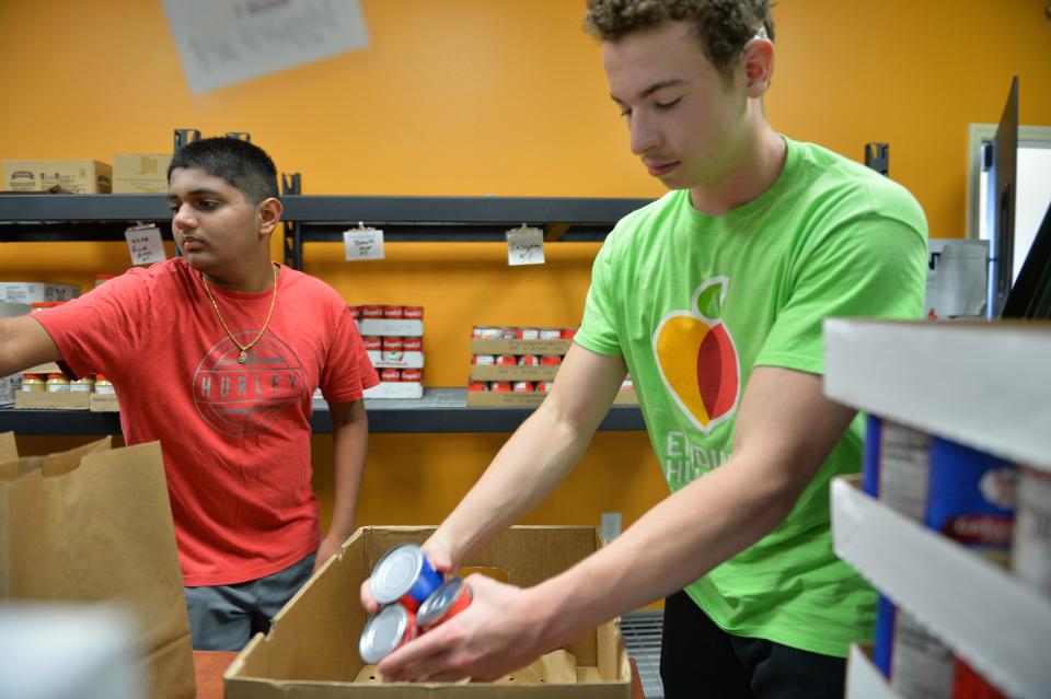 Volunteers Dhru Patel, left, and Stefan Roggendorf, assemble boxes of dry goods at the DeSoto Food and Resource Center in Arcadia. 