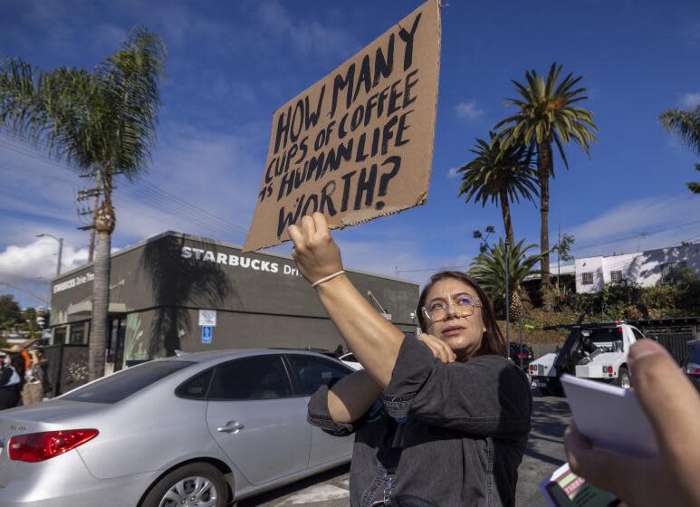 Los Angeles, CA - November 16: Volunteer organizer Elizabeth Fernandez holds a sign as a push to unionize Starbucks workers continues in front of a Starbucks store on Glendale Blvd. on Thursday, Nov. 16, 2023 in Los Angeles, CA. (Brian van der Brug / Los Angeles Times)