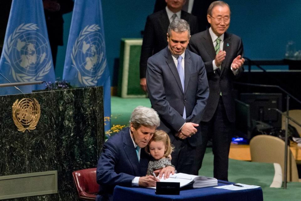 Secretary of State John Kerry holds his granddaughter as he signs the Paris Agreement on climate change, April 22, 2016 at U.N. headquarters (AP)