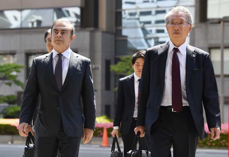 FILE PHOTO: Former Nissan Motor Co. Chairman Carlos Ghosn and his lawyer Junichiro Hironaka arrive at the Tokyo District Court for the first pretrial procedures in his financial misconduct case, in Tokyo