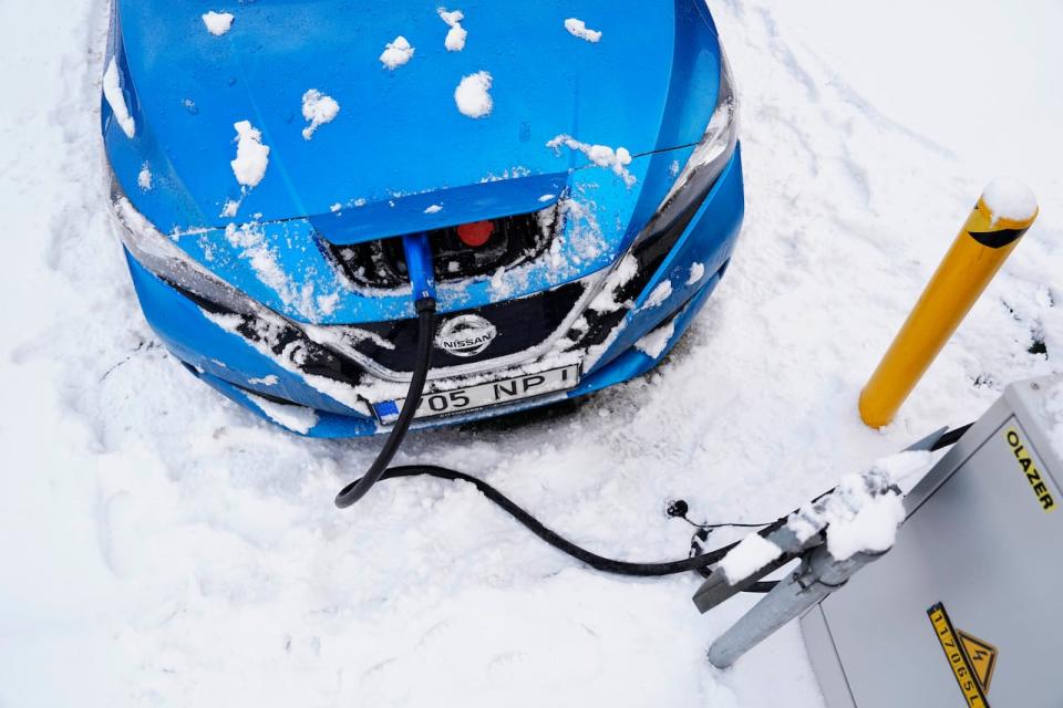 An electric car charges on a parking of a shopping mall in Tallinn, Estonia, Saturday, Feb. 11, 2023. Studies show that some EVs can lose up to 30 per cent of their range in freezing temperatures.