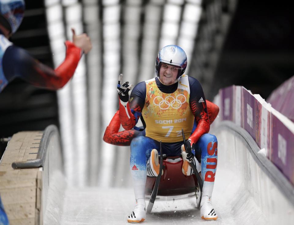 The Russian doubles team of Alexander Denisyev and Vladislav Antonov are greeted by teammates in the finish area after the luge team relay competition at the 2014 Winter Olympics, Thursday, Feb. 13, 2014, in Krasnaya Polyana, Russia. (AP Photo/Michael Sohn)