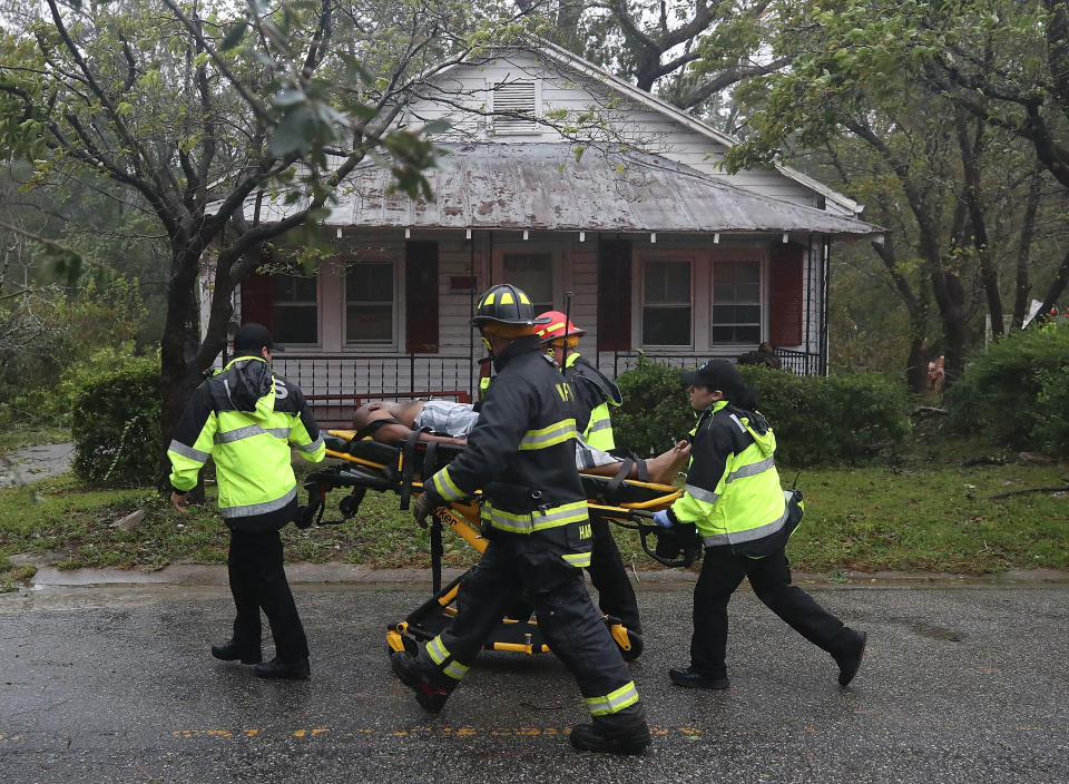 Rescue personnel remove a man from a home that a large tree fell on that had three people trapped after Hurricane Florence hit the area on Friday.