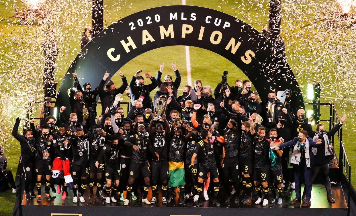 Columbus Crew SC defender Jonathan Mensah (4) hoists the Philip F. Anschutz Trophy to celebrate with his teammates after beating the Seattle Sounders FC 3-0 to win the 2020 MLS Cup at MAPFRE Stadium in Columbus, Ohio on December 12, 2020.