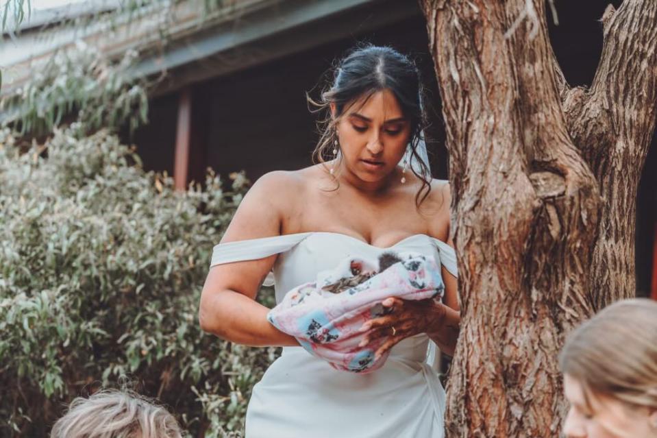 PJ in her wedding dress holding the possum. 