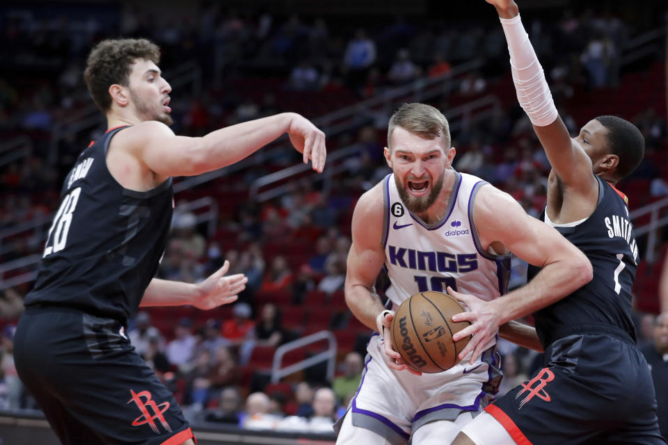 Sacramento Kings forward Domantas Sabonis, center, drives between Houston Rockets center Alperen Sengun, left, and Houston Rockets forward Jabari Smith Jr., right, during the first half of an NBA basketball game Monday, Feb. 6, 2023, in Houston. (AP Photo/Michael Wyke)