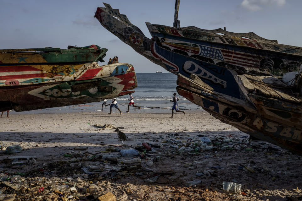 Youths play soccer on the beach in Thiaroye-Sur-Mer, Senegal, Friday, Aug. 23, 2024. Migrants leave on artisanal fishing boats known as pirogues and navigate for several days against strong winds and Atlantic currents. While thousands have survived the risky journey, many die or disappear along the way with remains sometimes washing up on the other side of the Atlantic. (AP Photo/Annika Hammerschlag)