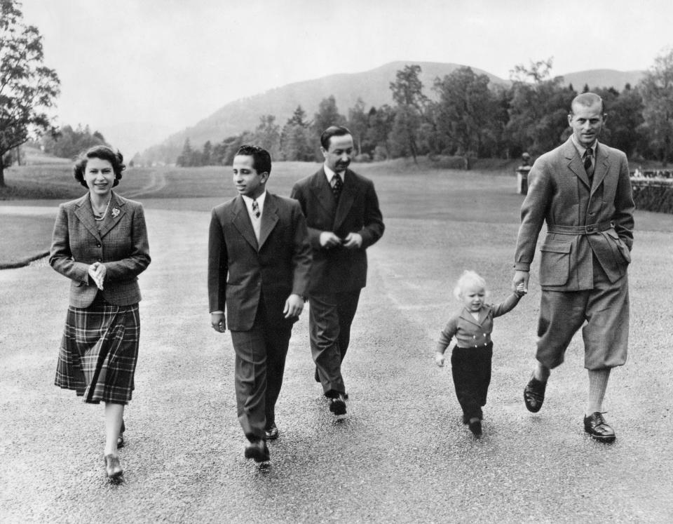 Queen Elizabeth II walking along with her daughter Princess Ann, Prince Philip, King Feisal II of Iraq (second left) take a stroll through Balmoral's grounds in 1952.(AFP via Getty Images)