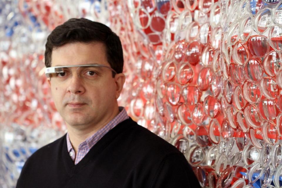 This undated image provided by Kiwi Arts Group shows David Datuna wearing a Google Glass device, with one of the works from his “Viewpoint of Billions” series behind him. Google Glass devices will be available during Art Basel Miami Beach, Dec. 5-8, for use by the public in interacting with Datuna’s works. (AP Photo/Kiwi Arts Group)