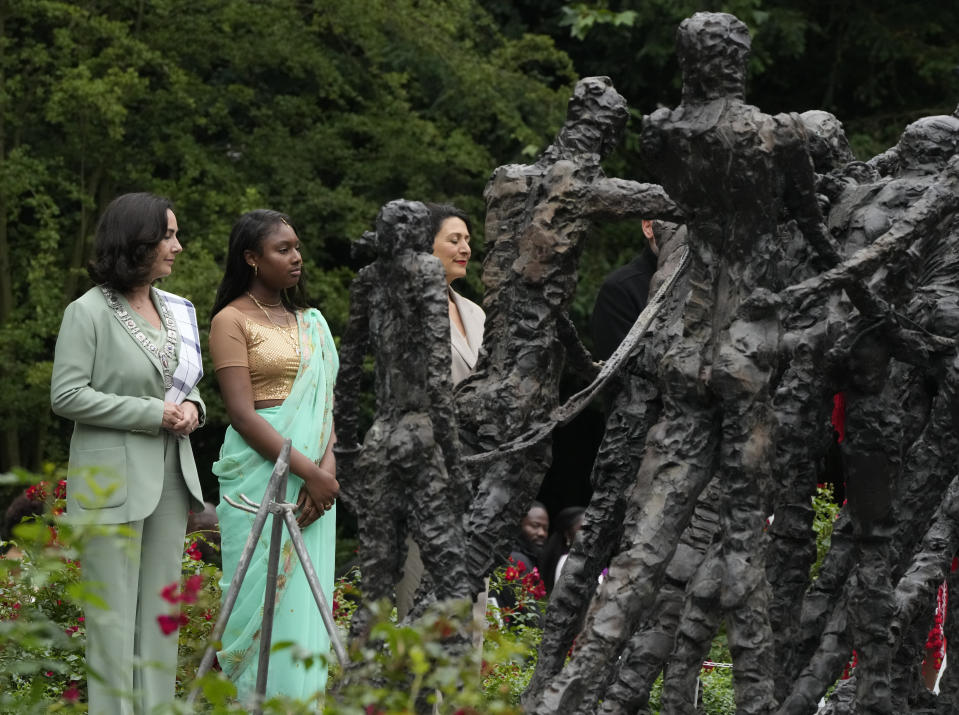 Mayor Femke Halsema, left, lays a wreath at the National Slavery Monument after apologizing for the involvement of the city's rulers in the slave trade during a nationally televised annual ceremony in Amsterdam, Netherlands, Thursday, July 1, 2021, marking the abolition of slavery in its colonies in Suriname and the Dutch Antilles on July 1, 1863. The anniversary is now known as Keti Koti, which means Chains Broken. Debate about Amsterdam's involvement in the slave trade has been going on for years and gained attention last year amid the global reckoning with racial injustice that followed the death of George Floyd in Minneapolis last year. (AP Photo/Peter Dejong)