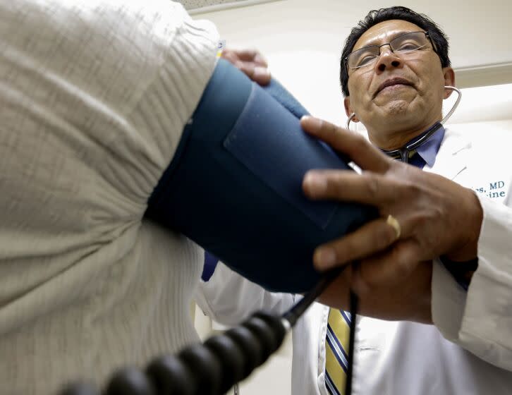 WHITTIER, CA, MAY 26, 2017: Dr. Juan Montes takes the blood pressure of a patient in his Whittier office May 26, 2017. Montes, the son of Santa Paula citrus workers became a doctor, as did his two brothers. He has run 4 medical clinics in the L.A. area for 35-years. In that time, clients have gone from mostly privately insured to mostly Medi-Cal or Medicare (Mark Boster / Los Angeles Times ).