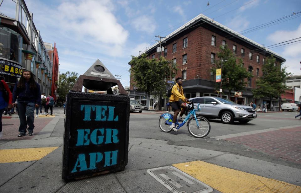 In this July 18, 2019, file photo, traffic and pedestrians cross Telegraph Avenue in Berkeley, California. The politically liberal city of Berkeley in Northern California decided last year to shift traffic enforcement from armed police to unarmed city workers. Supporters said the separation would curb racial profiling and reduce police encounters that can turn deadly, especially for Black motorists.