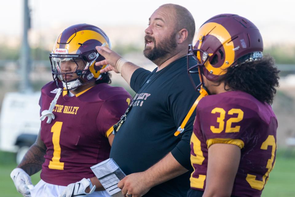 Victor Valley College head coach David Slover directs players while standing next to Lealofi Chanwong, left, and Napleone Taufa, an Adelanto High School graduate, during practice on Thursday, Aug. 31 2023. The Rams begin the season this weekend against Santa Monica College.