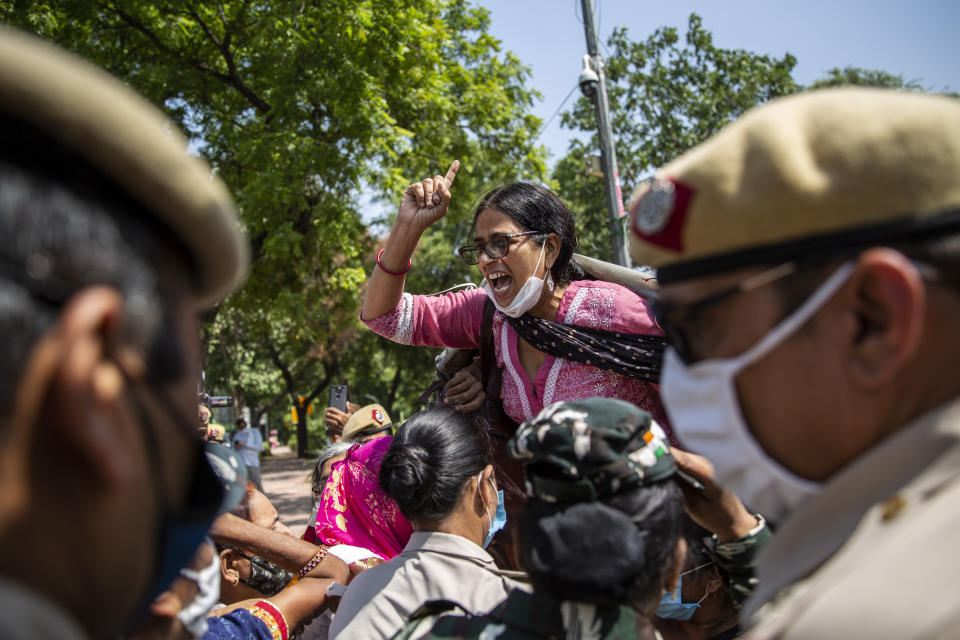 An Indian activist shouts slogans as she is detained by police during a protest in New Delhi, India, Wednesday, Sept. 30, 2020. The gang rape and killing of the woman from the lowest rung of India's caste system has sparked outrage across the country with several politicians and activists demanding justice and protesters rallying on the streets. (AP Photo/Altaf Qadri)