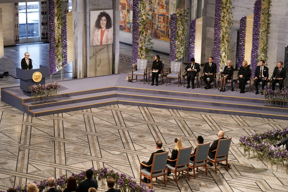 Chairman of the Nobel Committee Berit Reiss-Andersen speaks during the awarding of the Nobel Peace Prize for 2023 in Oslo City Hall, Oslo, Norway, Sunday, Dec. 10, 2023. The children of imprisoned Iranian activist Narges Mohammadi, shown on the screen, are set to accept this year’s Nobel Peace Prize on her behalf. Mohammadi is renowned for campaigning for women’s rights and democracy in her country. (Fredrik Varfjell/NTB via AP)