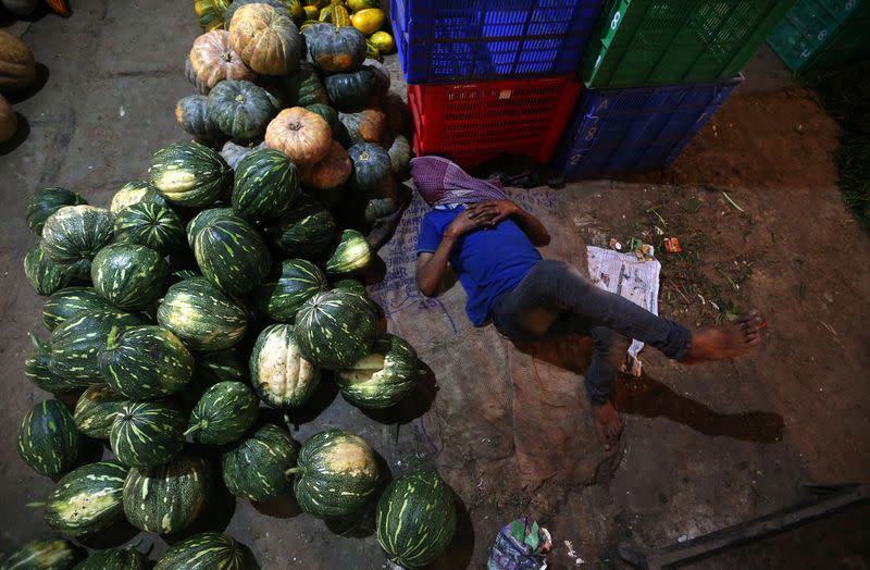 A worker sleeps at a wholesale market in Mumbai