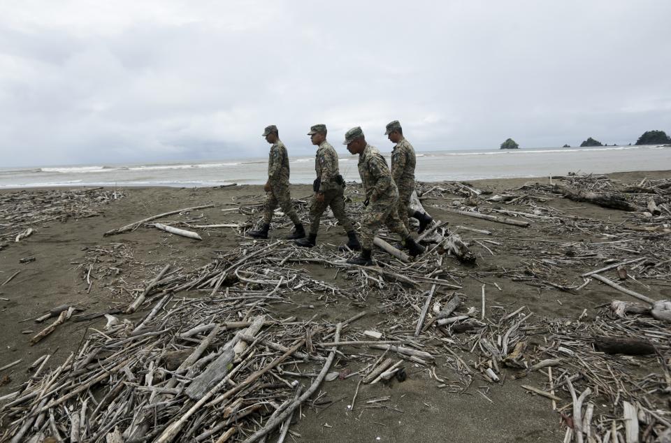 CORRECTS SPECIES OF TURTLES - In this Sept. 21, 2019 photo, Panama border police officers walk on a beach where the endangered olive ridley sea turtles lay their eggs, in Jaque, Panama. Police officers try to prevent poaching and protect the volunteers on their nightly collections. (AP Photo/Arnulfo Franco)