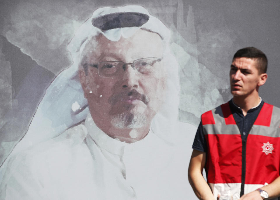 A Turkish police officer walks past a picture of slain Saudi journalist Jamal Khashoggi prior to a ceremony, near the Saudi Arabia consulate in Istanbul, marking the one-year anniversary of his death, Wednesday, Oct. 2, 2019. A vigil was held outside the consulate building Wednesday, starting at 1:14 p.m. (1014 GMT) marking the time Khashoggi walked into the building. (AP Photo/Lefteris Pitarakis)