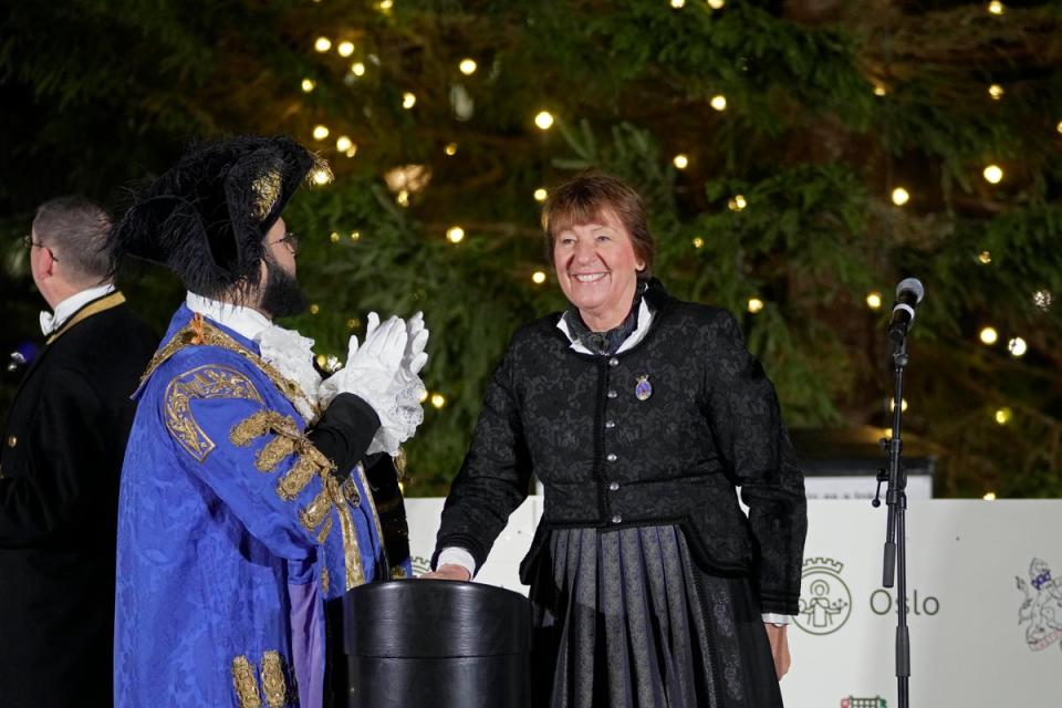 The Mayor of Oslo Marianne Borgen, right, presses a button during the annual Norwegian Christmas tree lighting ceremony in Trafalgar Square, in London, Thursday, Dec. 1, 2022. (AP)
