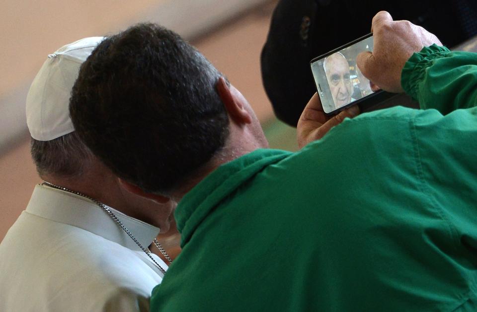 Pope Francis (L)  poses for a selfie photograph during his visit to the Santa Maria Regina Pacis church on May 3, 2015, in Ostia, south of Rome. AFP PHOTO / ALBERTO PIZZOLI        (Photo credit should read ALBERTO PIZZOLI/AFP/Getty Images)