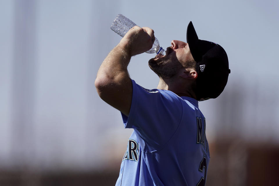 Seattle Mariners' Tom Murphy takes a drink during baseball spring training Thursday, Feb. 25, 2021, in Peoria, Ariz. (AP Photo/Charlie Riedel)