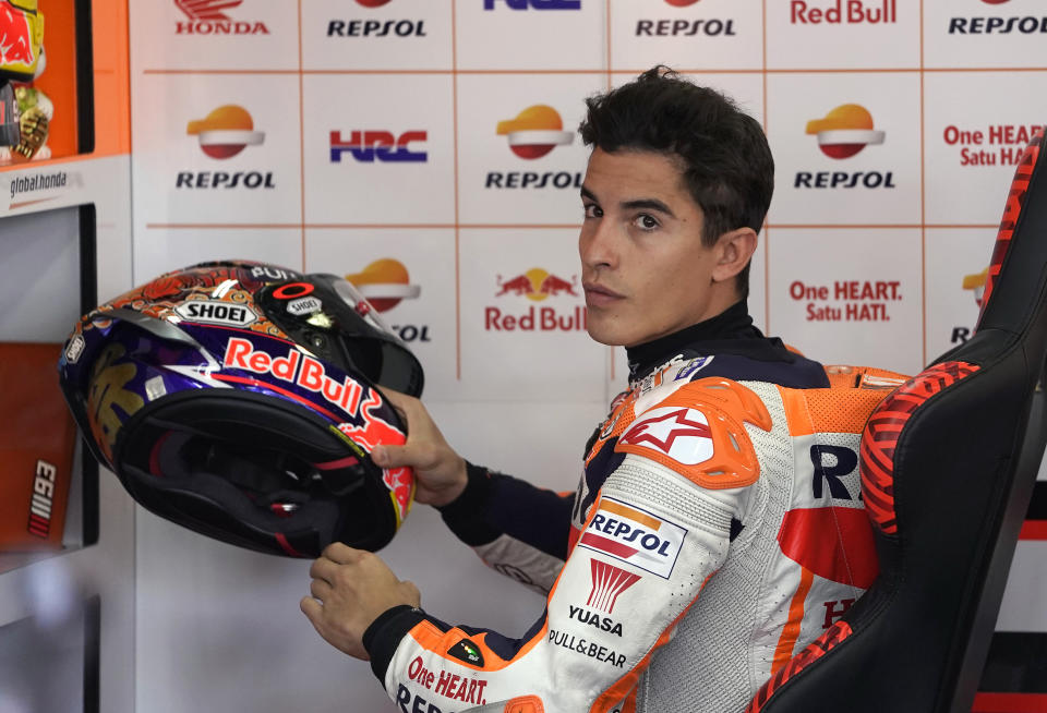 Spain's rider Marc Marquez takes up a helmet in the pits during the MotoGP Japanese Motorcycle Grand Prix at the Twin Ring Motegi circuit in Motegi, north of Tokyo, Sunday, Oct. 21, 2018. (AP Photo/Shizuo Kambayashi)