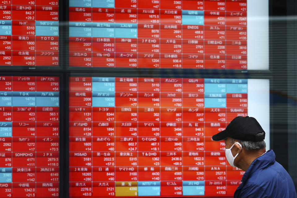 A man wearing a protective mask looks at an electronic stock board showing Japan's Nikkei 225 index at a securities firm Thursday, May 6, 2021, in Tokyo. Asian shares were mixed Thursday on cautious optimism about upcoming company earnings reports showing some recovery from the damage of the coronavirus pandemic. (AP Photo/Eugene Hoshiko)