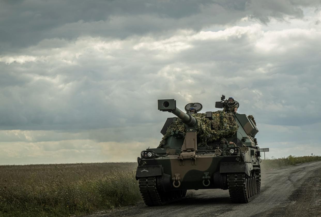 Ukrainian servicemen ride a self-propelled howitzer near the Russian border in Ukraine's Sumy region on August 11.